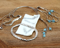 A close-up photo of a person cleaning a sterling silver bracelet with a polishing cloth.