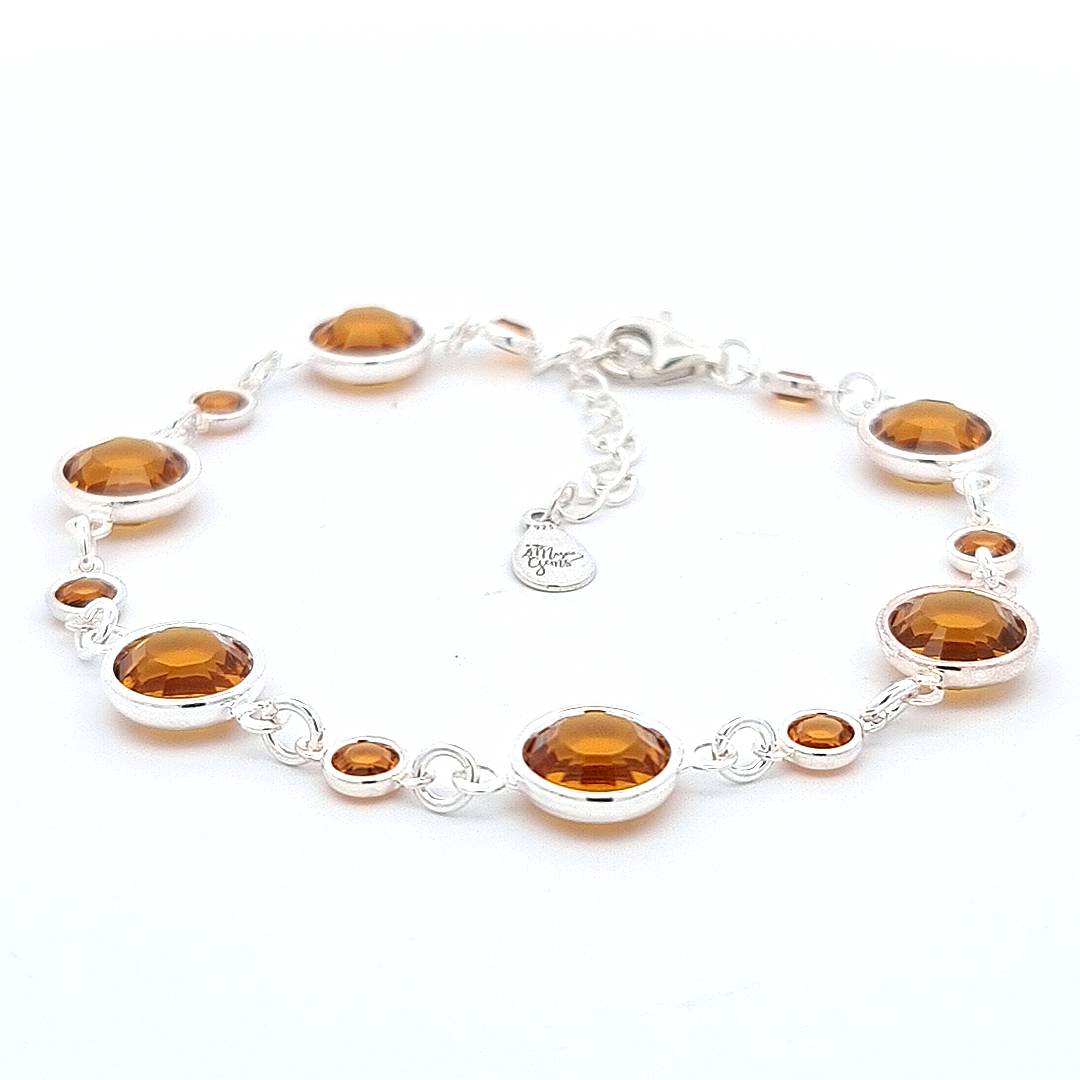 Handmade November birthstone bracelet from Ireland, sterling silver links are graced with topaz crystals, symbolizing strength and intellect.