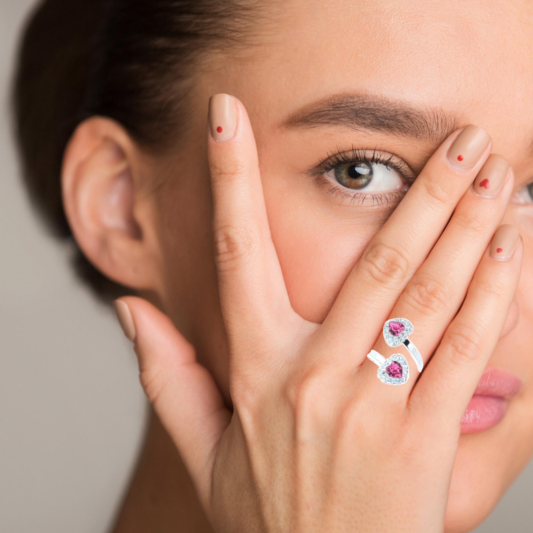 Women wearing a Rose Pink Heart Wrap-around ring in sterling silver with heart pave ends, showcasing brilliant gemstones.