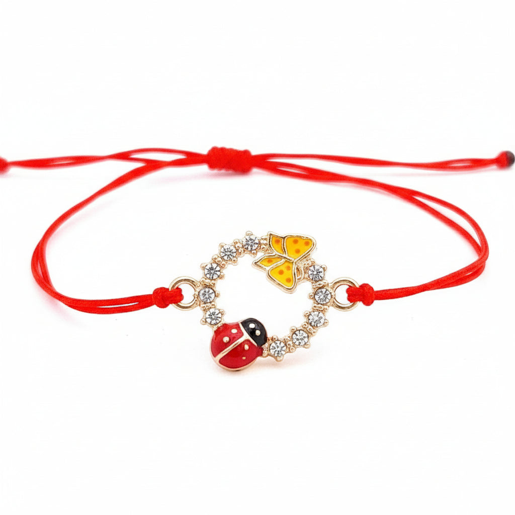 Vibrant 'Spring's Promise' Martisor Bracelet with a gold-tone circle charm adorned with crystals, an enameled ladybird, and butterfly, on a red macramé cord handmade in Ireland.