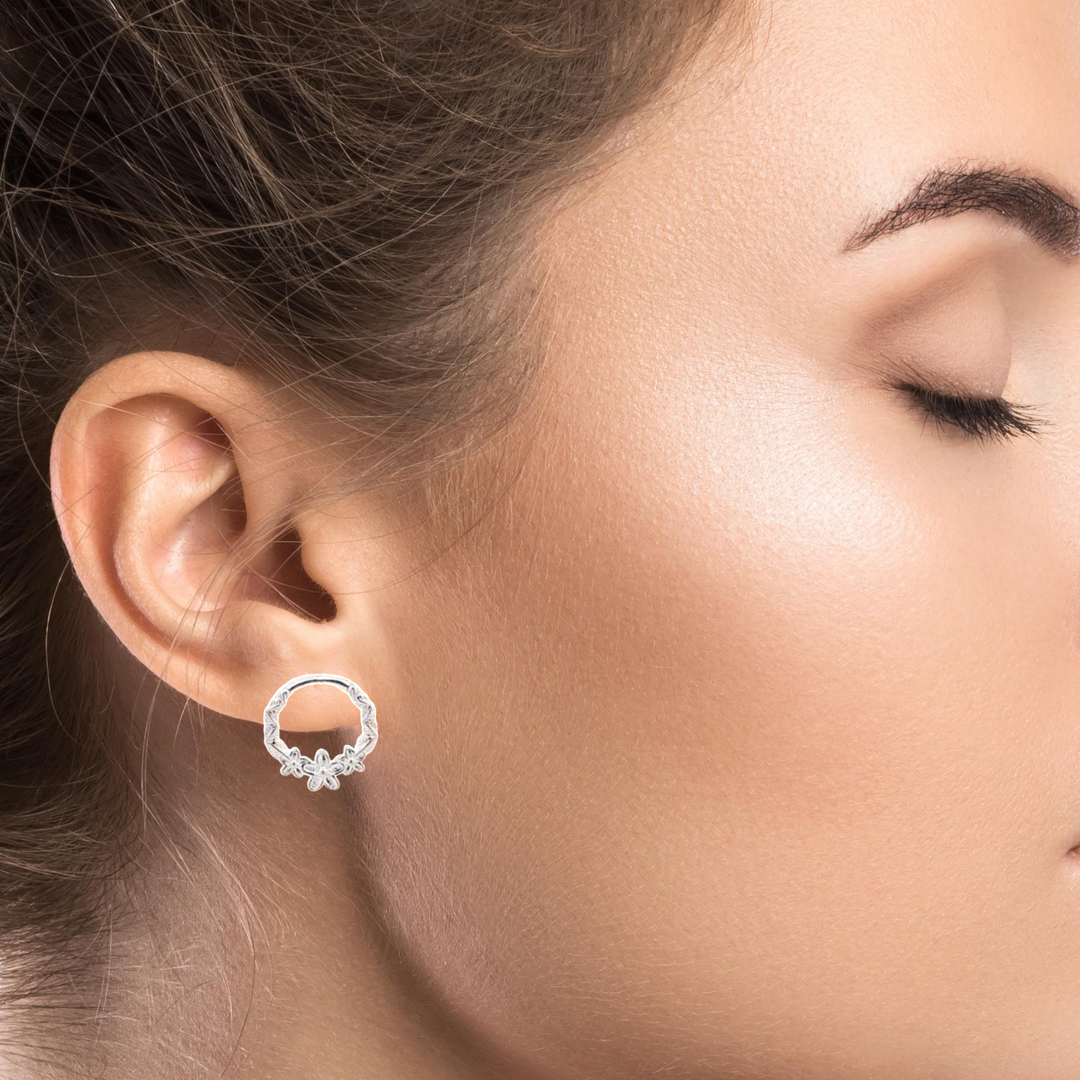 Elegant woman wearing Nature's Blossom Sterling Silver Earstuds, adding a touch of nature-inspired charm to her look, from Ireland.