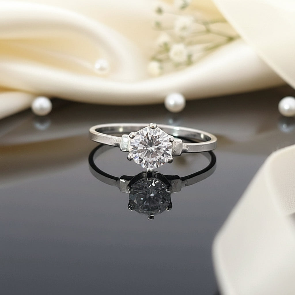 Nickel-free sterling silver solitaire ring with round cubic zirconia reflected on black surface, handcrafted by Magpie Gems Ireland.