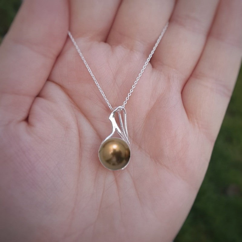 Hand holding a Copper Crystal pearl luster necklace on a sterling silver chain from Ireland