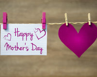A heartwarming display for Mother's Day featuring a large heart and a handwritten note that reads "Happy Mother's Day" attached to a string with pegs. The heartfelt display is a beautiful reminder of the love and appreciation we have for our mothers.