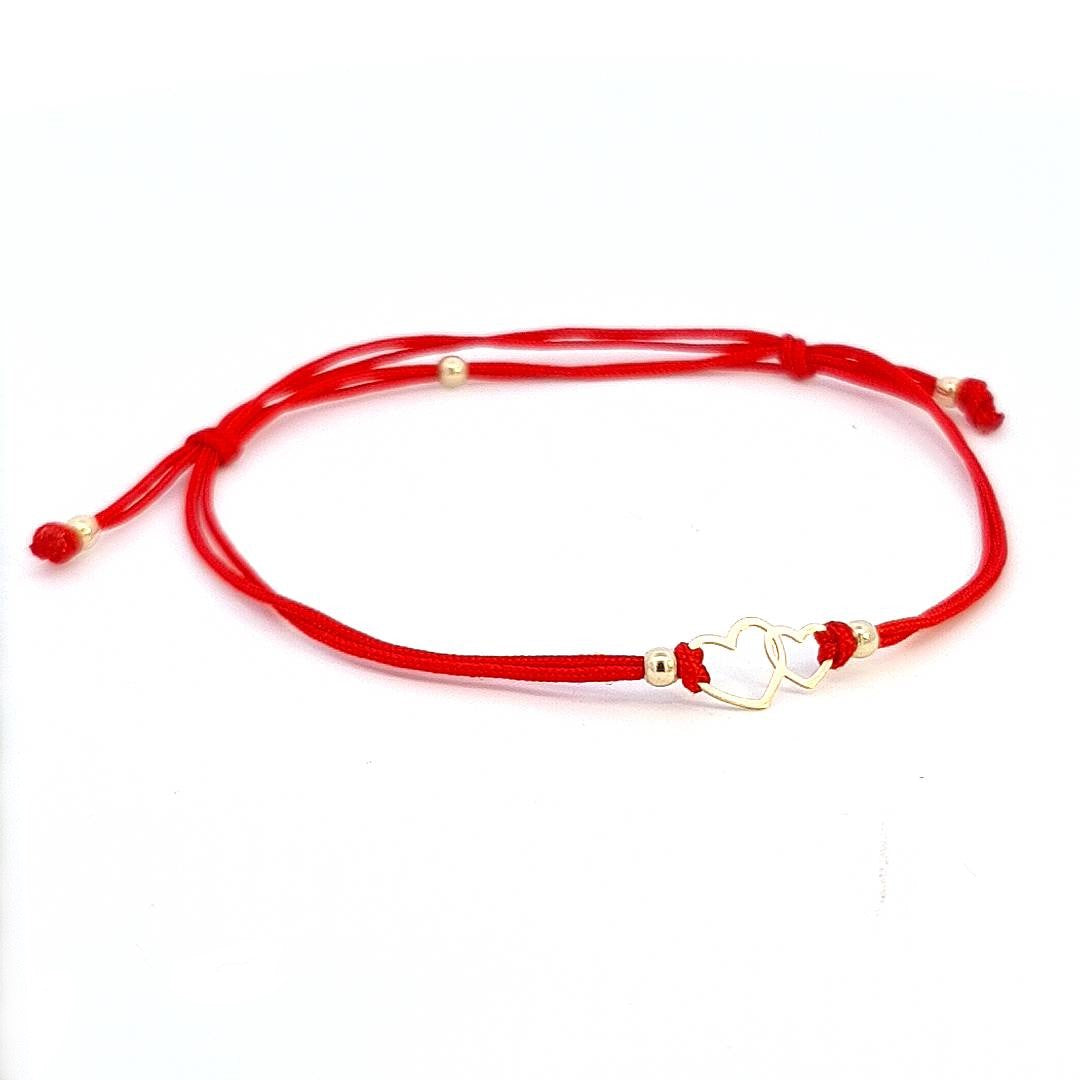 Front view of the Hearts of Harmony Solid Gold Bracelet showcasing the intertwined 14k gold hearts on a vibrant red string.