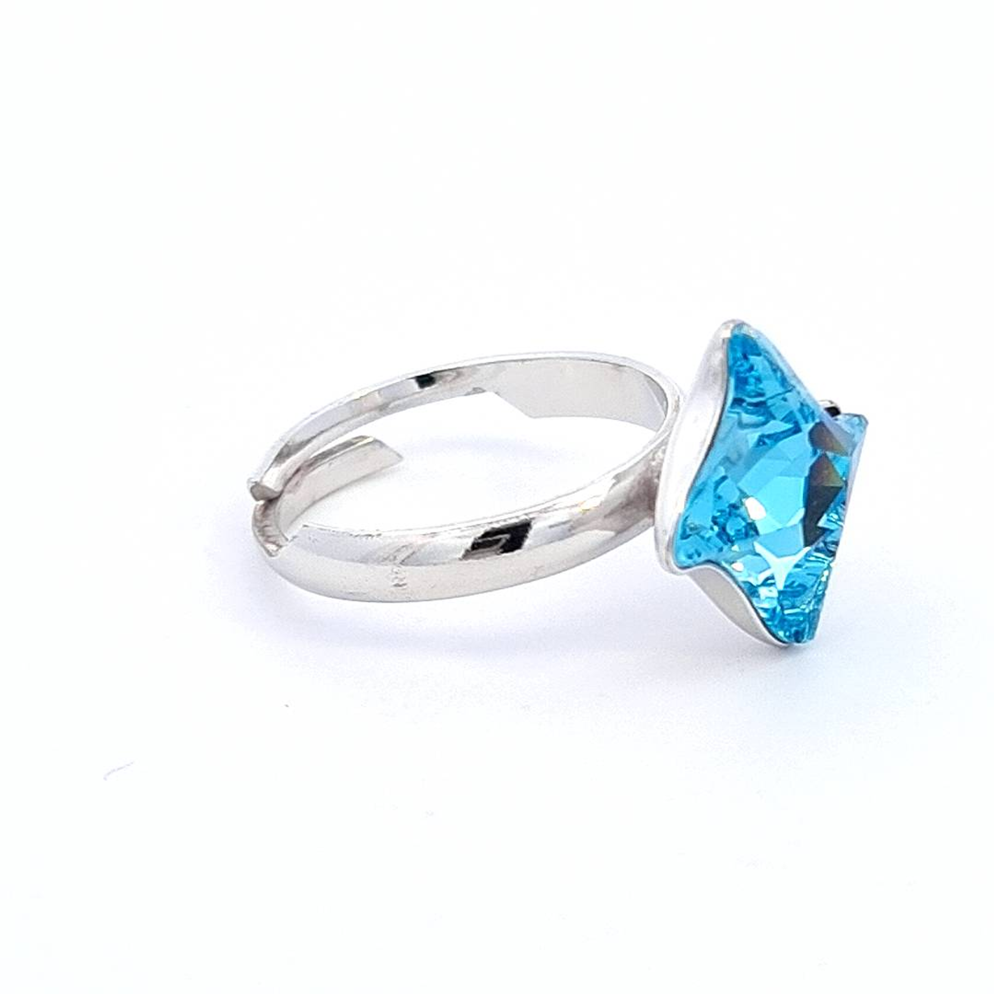 Side profile of the Aquamarine Solitaire Ring by Magpie Gems, featuring the intricate twister design and side-set crystals that complement the central aquamarine stone.
