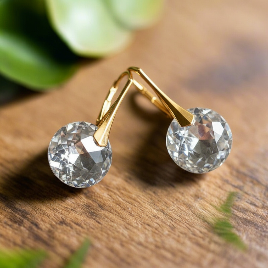 Gold-plated April birthstone drop earrings with clear Austrian crystals on a polished hook design, handcrafted in Ireland by Magpie Gems.