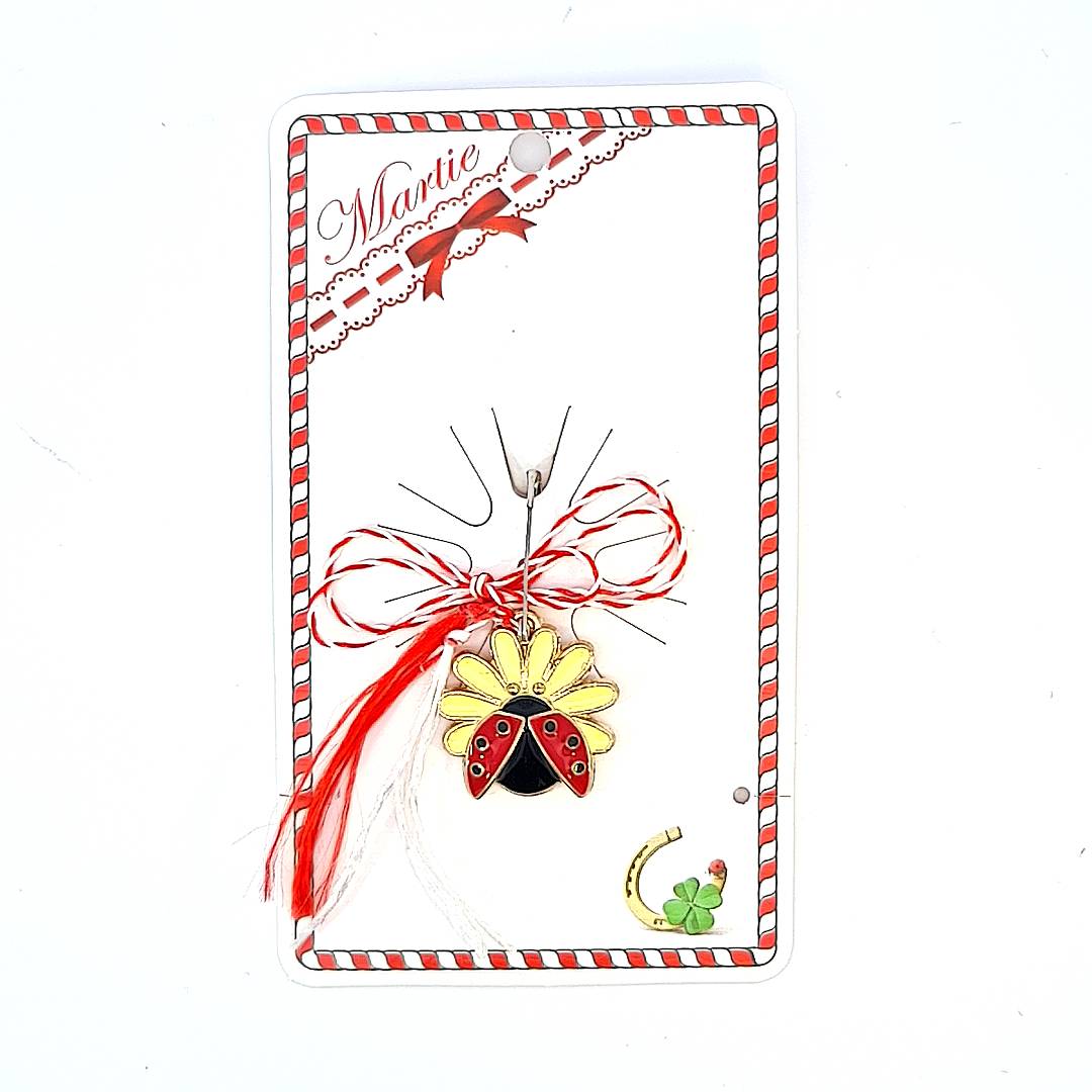 Gold ladybug Martisor charm with a vibrant yellow enamel flower, bound with the traditional red and white string of Martisor, symbolising good fortune.