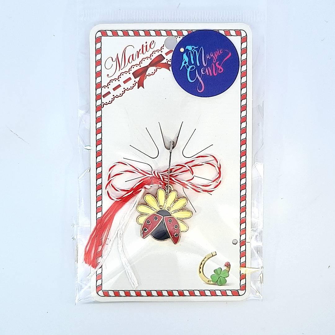 Packaged 'Blossoming Luck' Martisor charms showing ladybugs on white, yellow, and peach flowers, each tied with a red and white string.