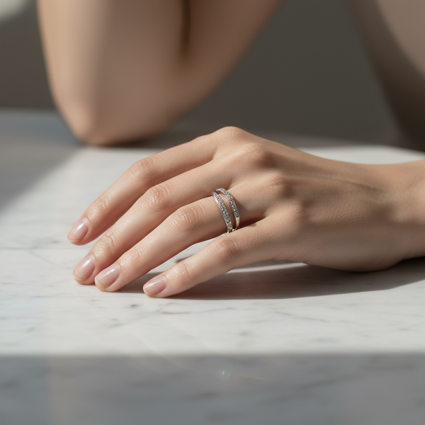Hand wearing a silver ring on a marble surface