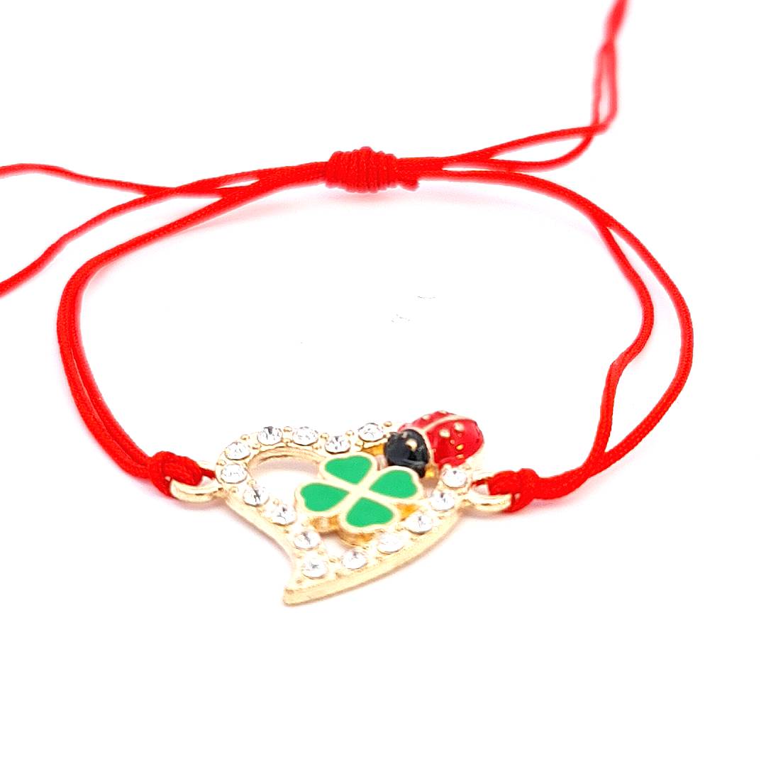 Elegant 'Luck and Love' Martisor Bracelet featuring a gold-plated heart with crystal edges, green enamel four-leaf clover, and a red ladybird on an adjustable red cord. Friendship Bracelet made in Ireland