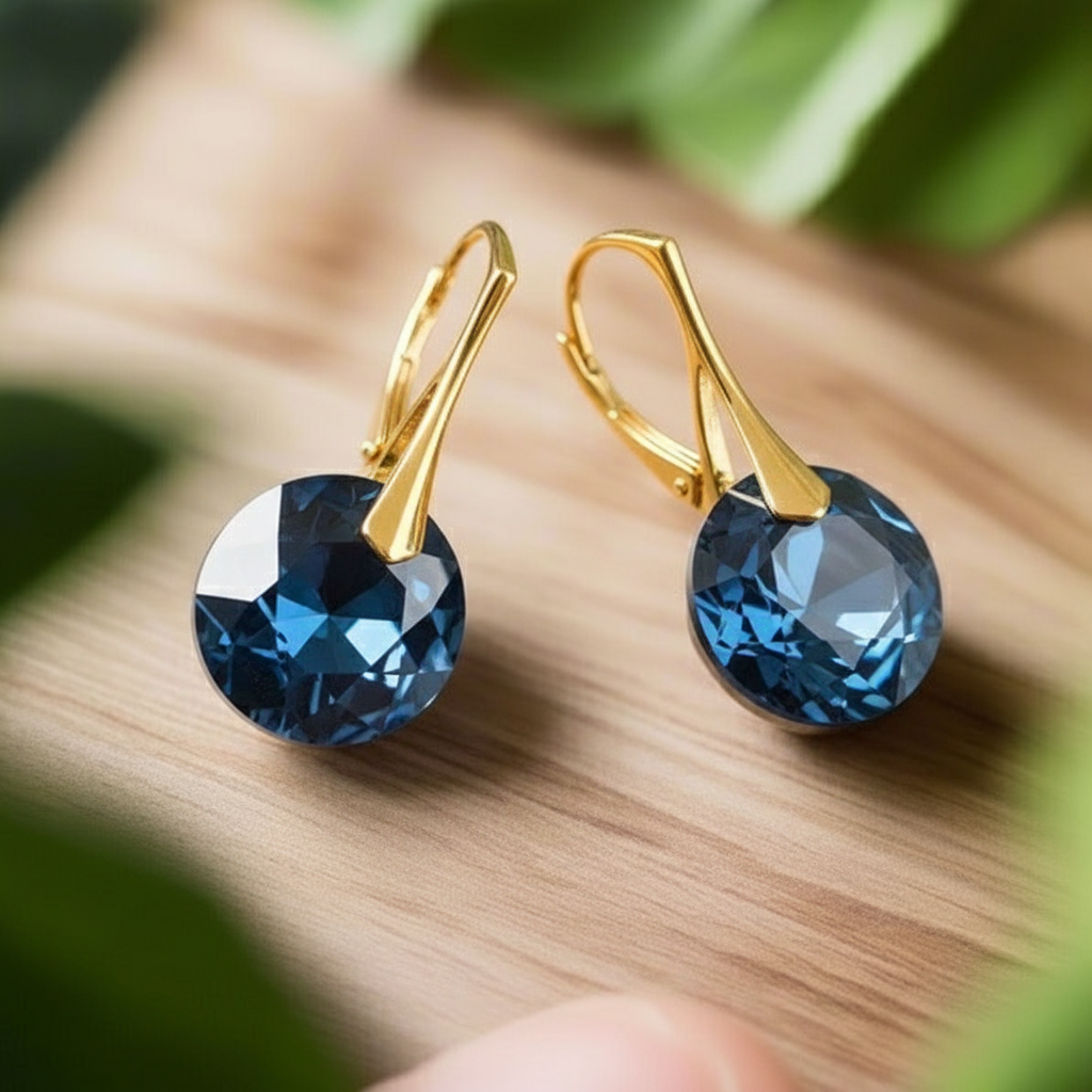 A pair of gold drop earrings with round chaton crystals in the colour Montana blue as December birthstone.