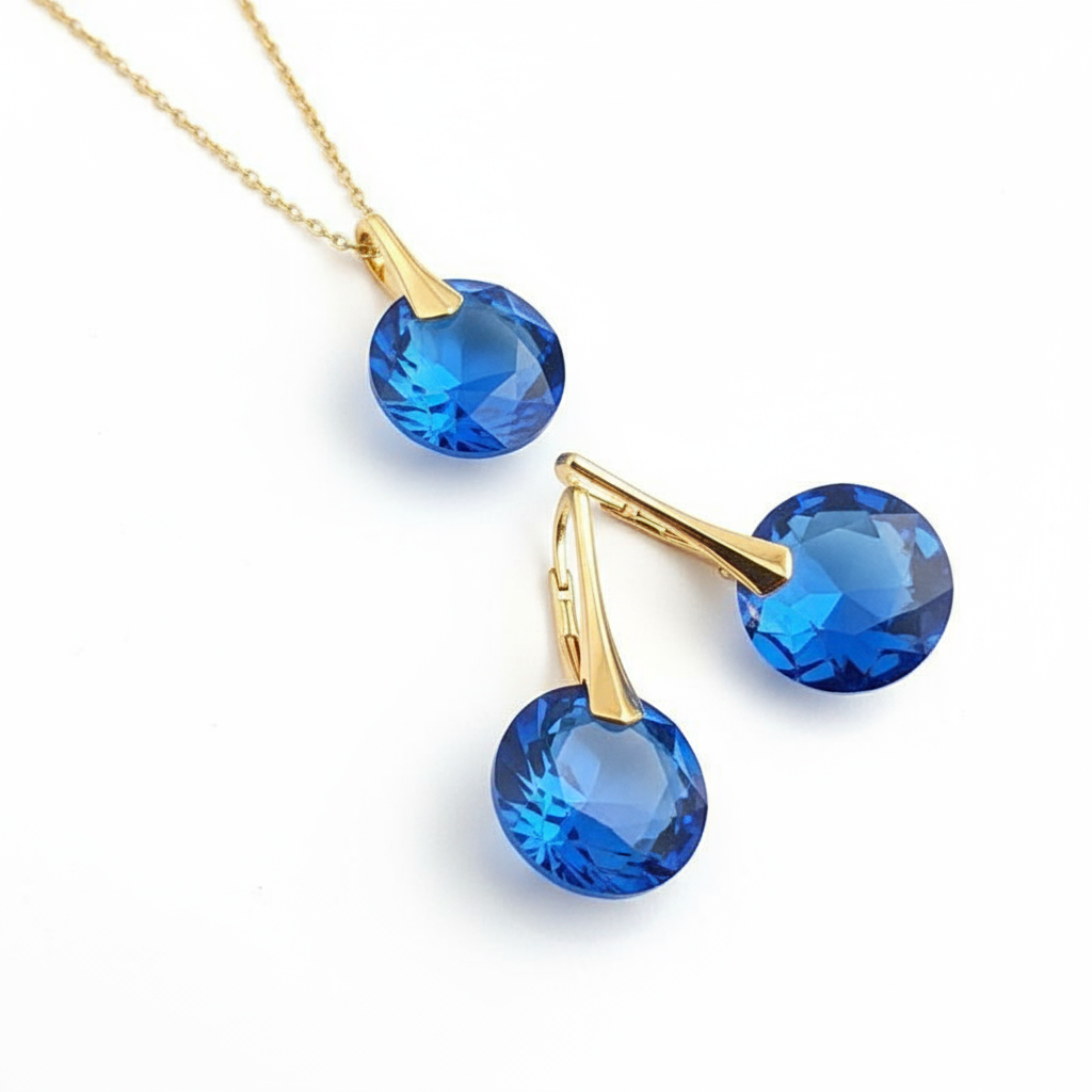 Gold necklace and earrings with blue gemstones. September birthstone jewellery set with Sapphire blue 14mm Austrian crystal necklace and leverback earrings in sterling silver by Magpie Gems.