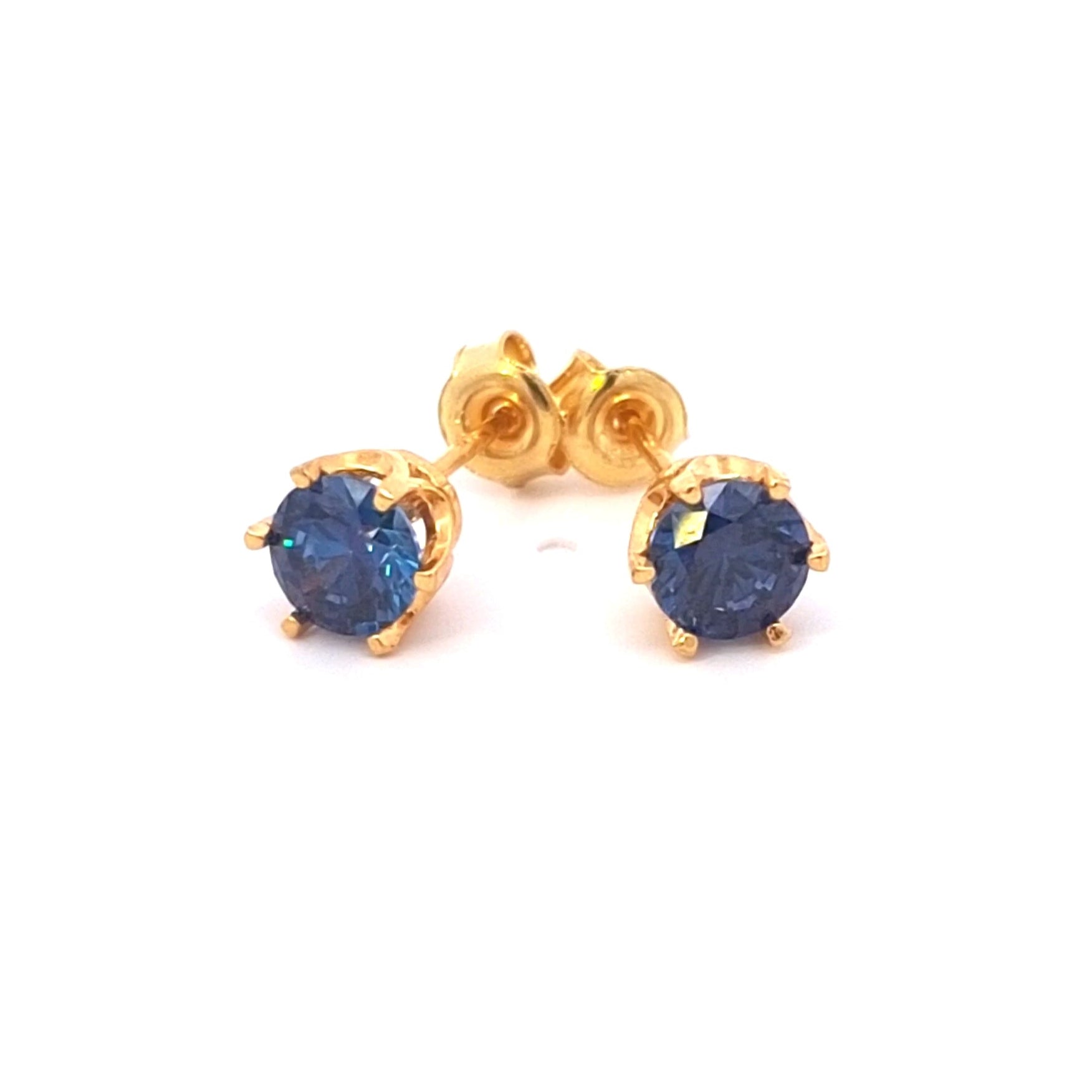 Gold earrings with blue gemstones on a white background. Royal blue Cubic Zirconia earrings set in 24k gold-plated silver