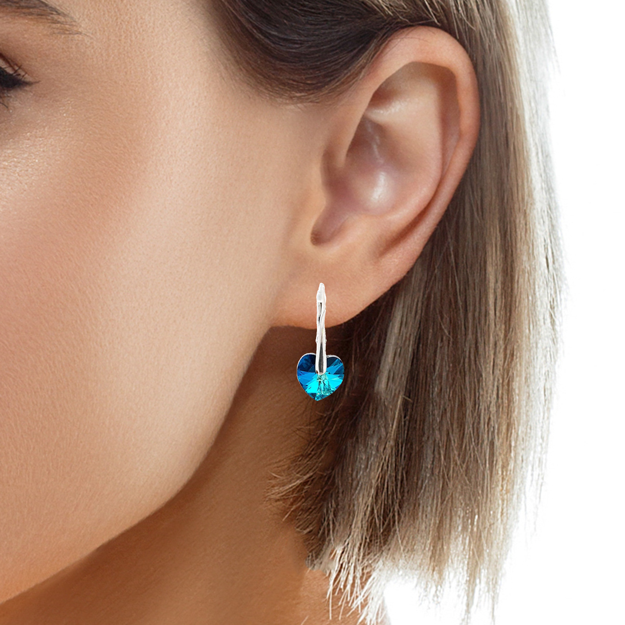 Elegant Woman Wearing Bermuda Blue Dainty Heart Earrings - Reflecting the Serenity and Beauty of the Sea