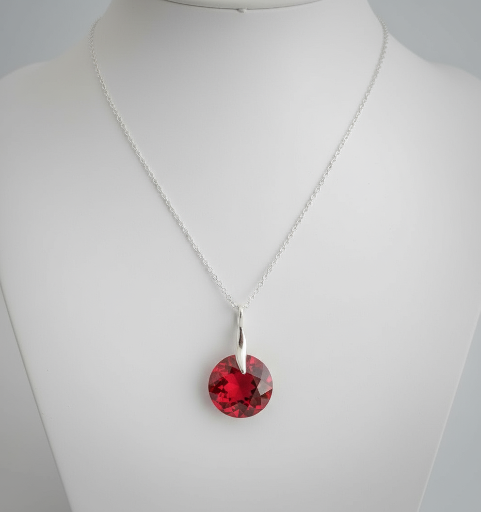 Necklace with a red pendant on a mannequin against a gray background