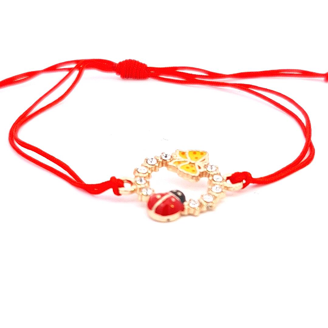 Vibrant 'Spring's Promise' Martisor Bracelet with a gold-tone circle charm adorned with crystals, an enameled ladybird, and butterfly, on a red macramé cord handmade in Ireland.
