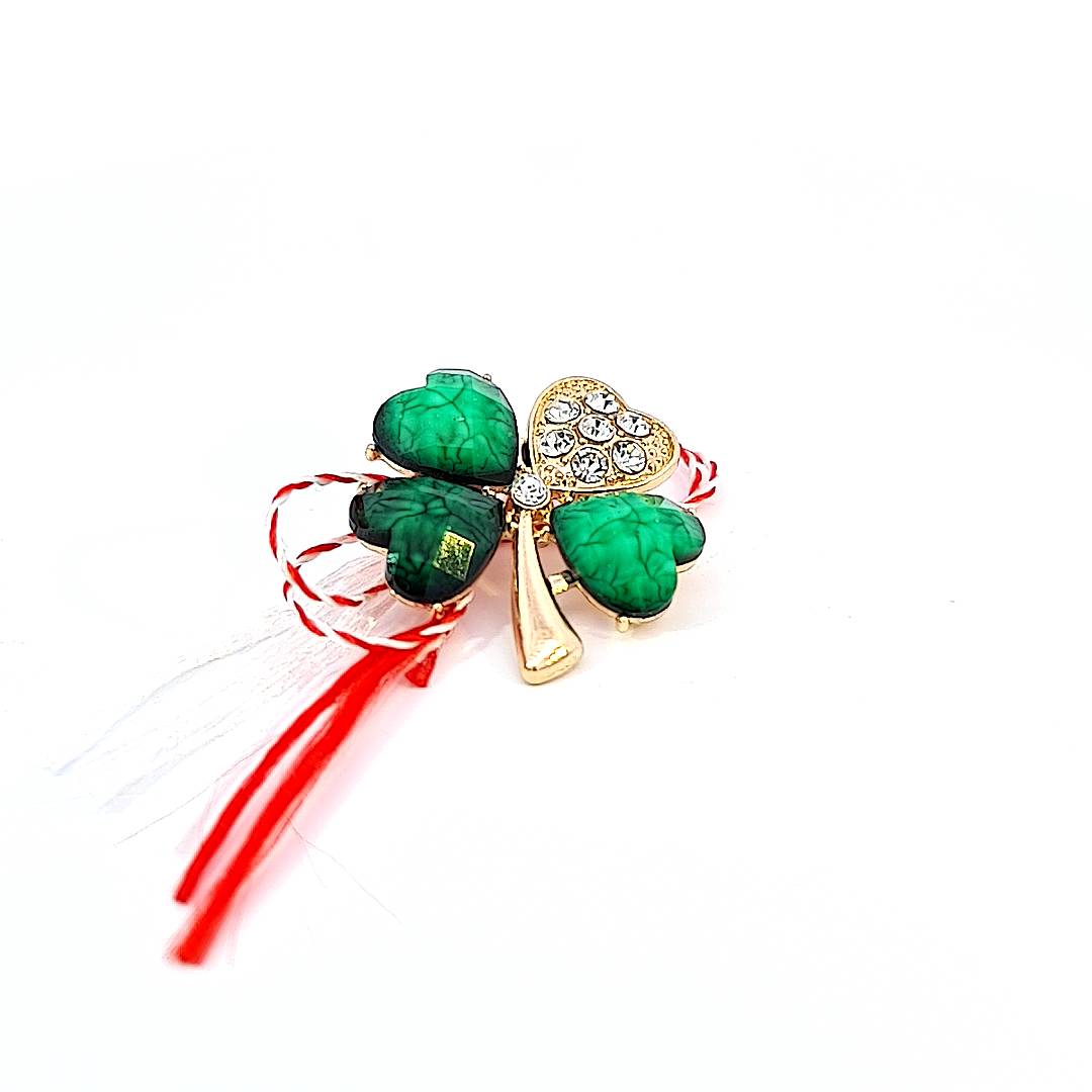 The 'Emerald Gleam' Martisor brooch shines with deep green enamel, elegantly presented with a traditional Martisor string.