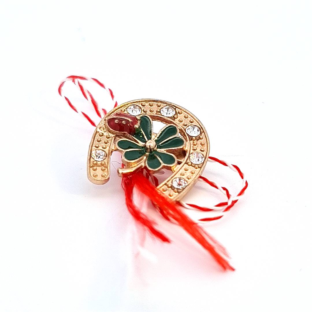 Front view of the 'Lucky Clover Horseshoe' Martisor brooch featuring a green enamel clover and crystal embellishments on a gold-plated setting.