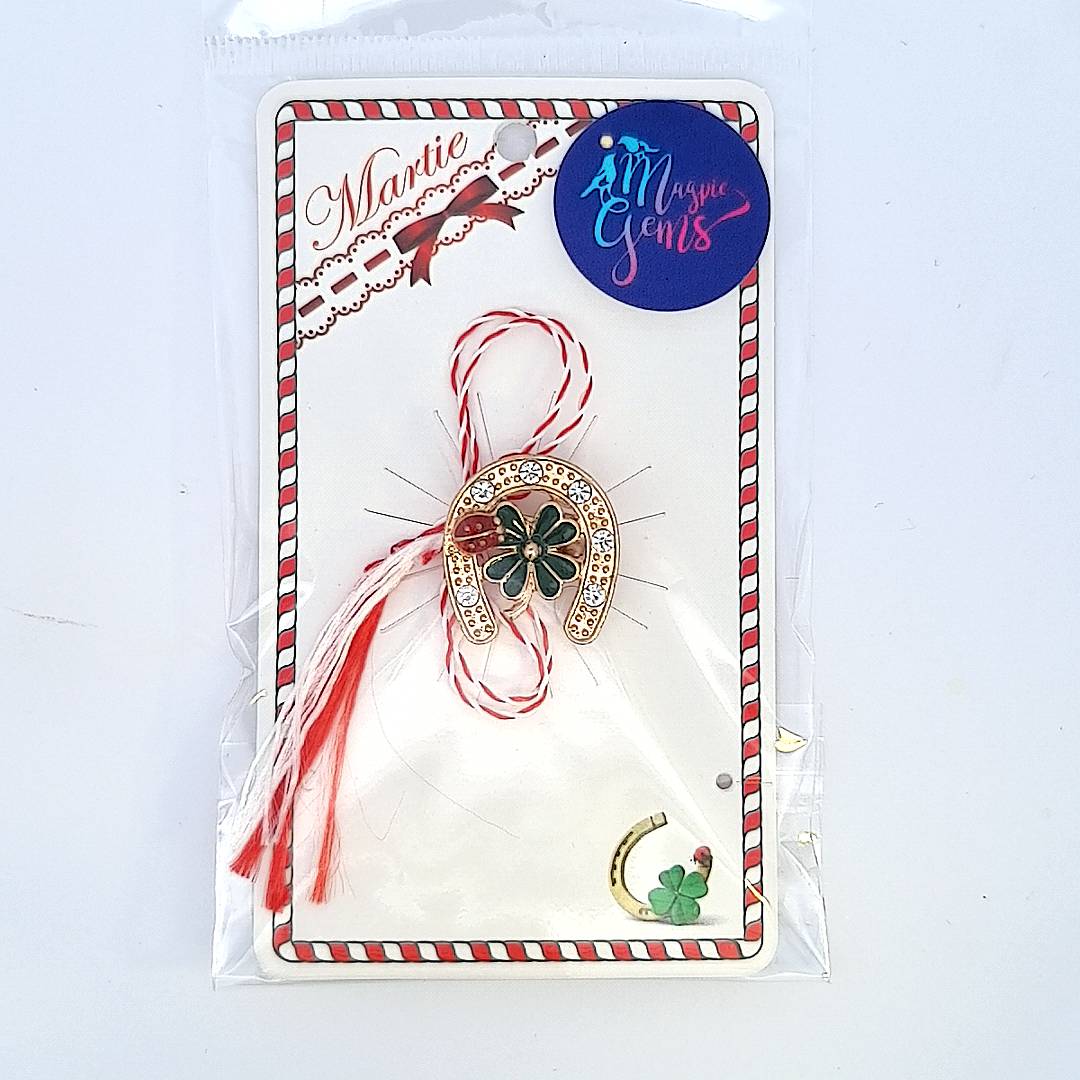 Packaged 'Lucky Clover Horseshoe' Martisor brooch by Magpie Gems, displayed with the traditional red and white string of the Martisor celebration.