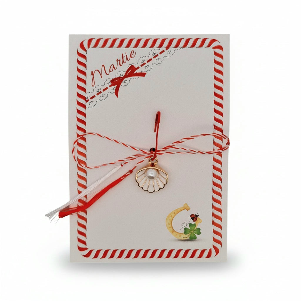 Traditional Mărtișor gift presented on decorative card with red and white string and shell pearl charm, symbolising spring, luck and new beginnings.