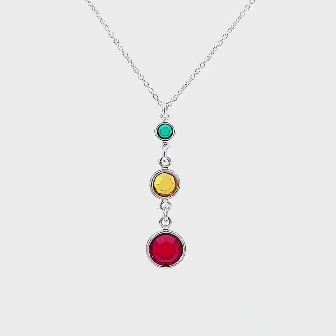 "360-degree video showcasing the Sterling Silver Three Generations Birthstone Necklace from Magpie Gems, featuring rotating views of the tiered birthstones in various sizes, elegantly crafted in sterling silver with Swarovski crystals, highlighting the fine details and craftsmanship, set against a softly lit background to enhance the necklace's beauty."