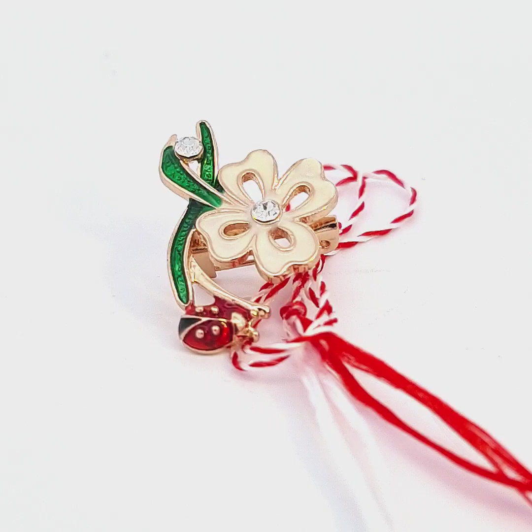 Video schocasing the 'Springtime Bloom' Martisor brooch presented with the red and white string, symbolising the Martisor tradition.