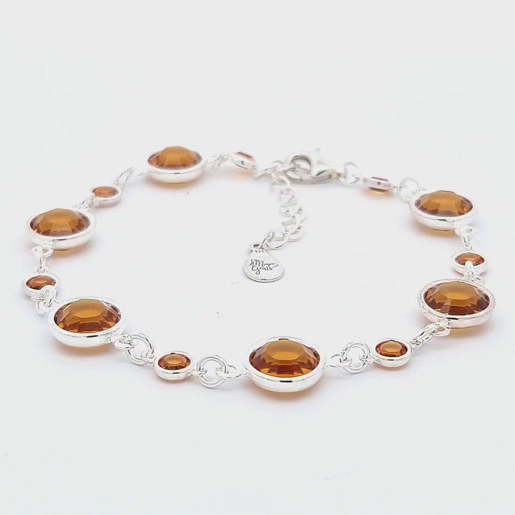 Video showcasing the November birthstone sterling silver link bracelet, with each link elegantly holding a topaz crystal, shimmering with an autumnal golden glow. The handcrafted piece reflects light beautifully as it moves, highlighting the exquisite craftsmanship and ethical sourcing from Ireland.