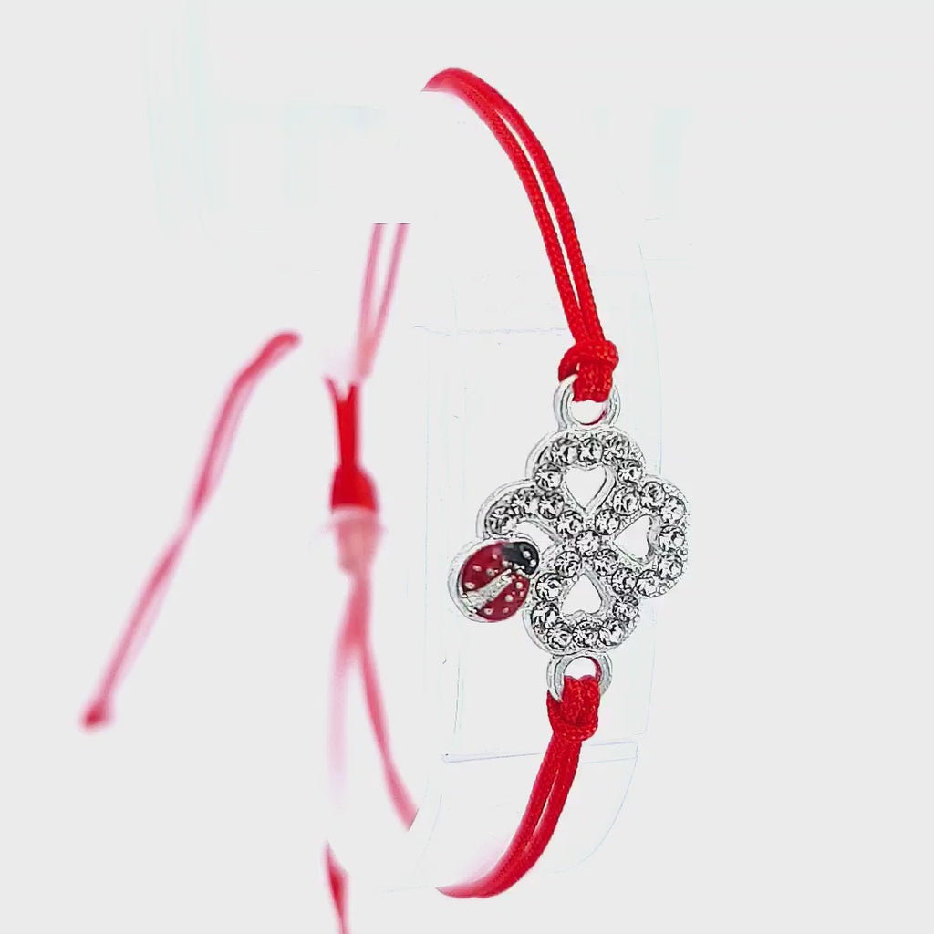 Video demonstrating the 'Ladybird Luck Clover' Martisor Bracelet on a white background, showcasing the sparkling crystals and the vivid enamel ladybird as the bracelet gently sways, reflecting light.