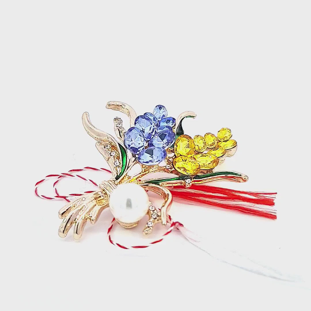 Showcase video of the 'Pearlescent Harmony' Martisor brooch, highlighting the sparkling crystals and faux pearl, along with the included storytelling card explaining the Martisor tradition, all bound by the symbolic red and white string.