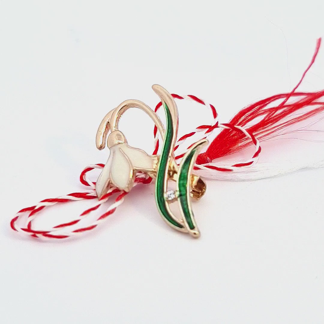 Video showcasing the 'Emerging Snowdrop' Martisor brooch, presented with the red and white Martisor string, symbolising the beginning of spring.