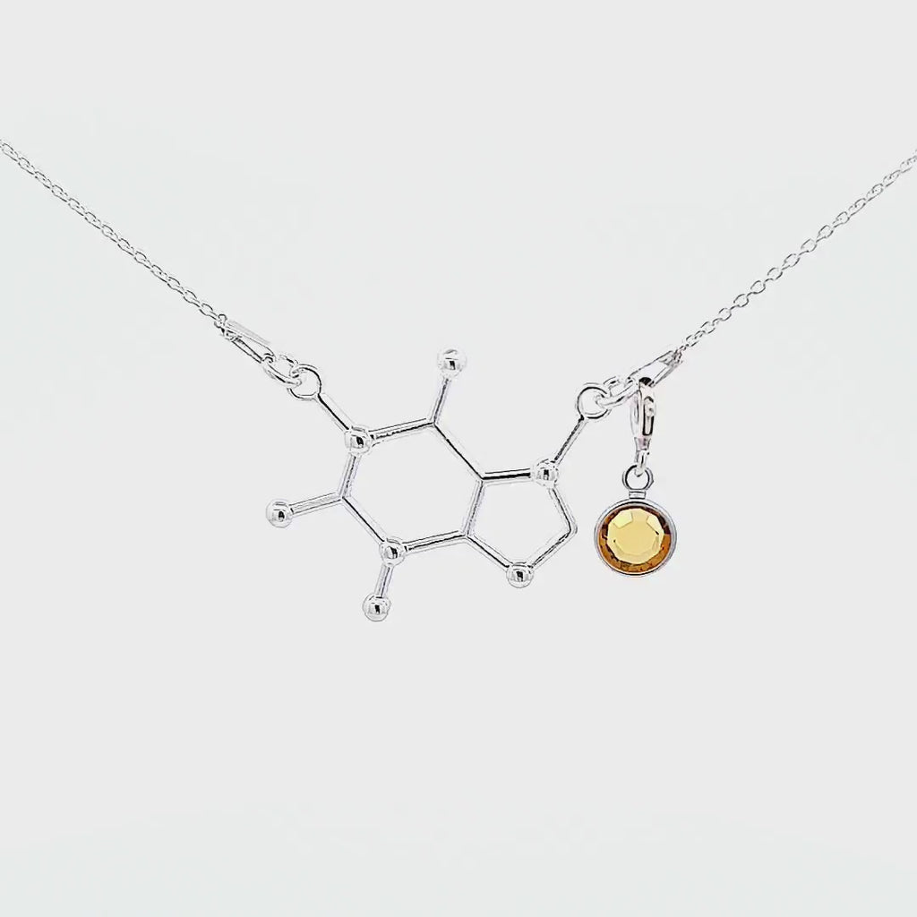 Short video of a silver necklace with a caffeine molecule for the coffee lovers., and with a november birthstone