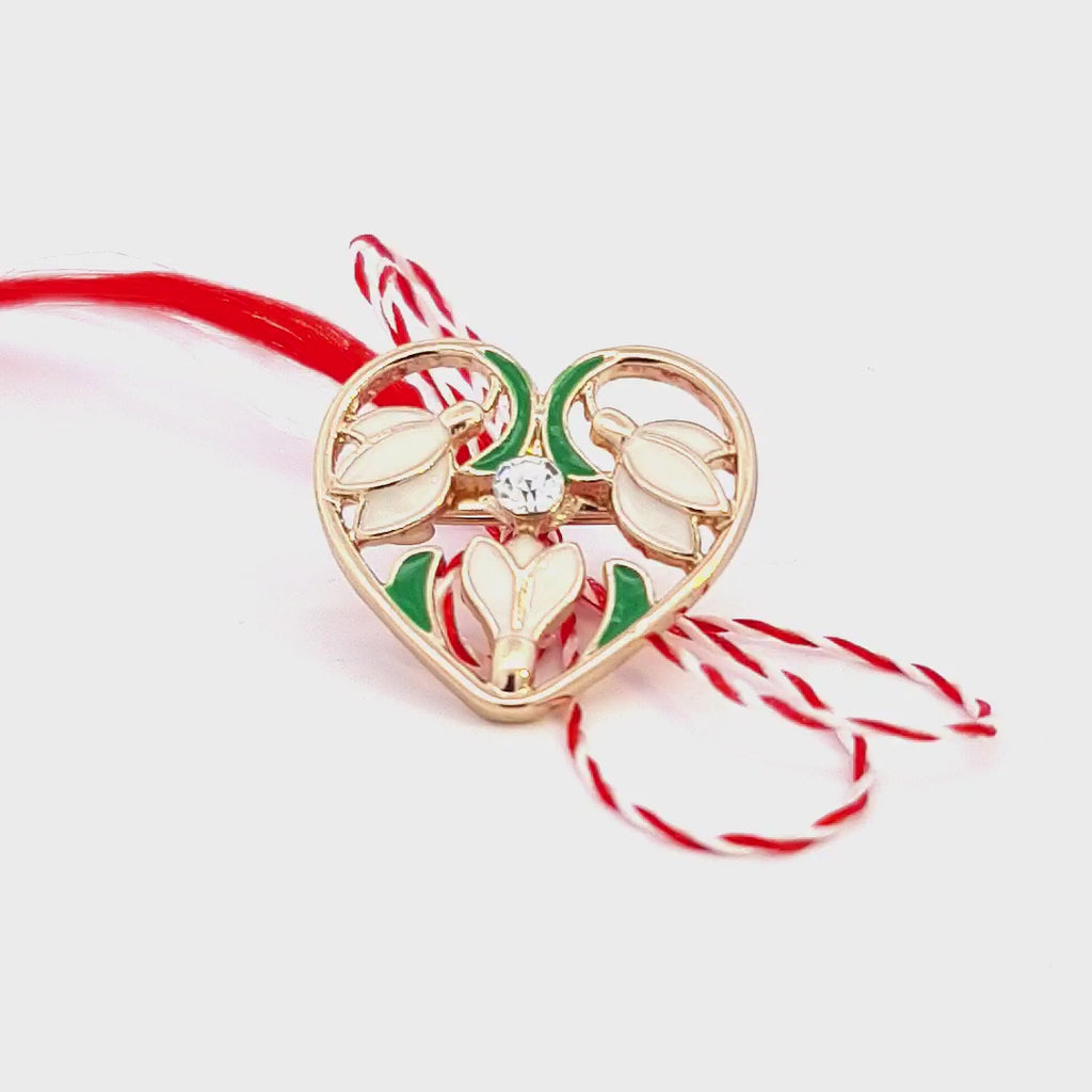 Video demonstration of the 'Heart of Spring' Martisor brooch, highlighting the gold-plated finish, enamel detail, and crystal embellishment from multiple angles.