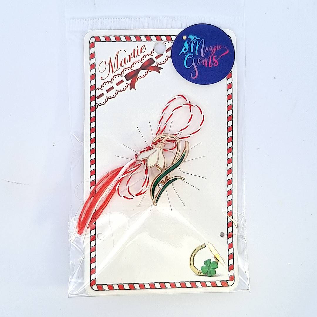 The 'Emerging Snowdrop' Martisor brooch, presented with the red and white Martisor string, symbolising the beginning of spring with a Martisor's story card and clear bag ready for gift giving on 1st of March.