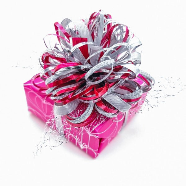 Magpie Gems signature pink gift wrapped box with intricate silver and pink handcrafted bow, symbolising the brand's commitment to elegance and personal touch in international gifting.