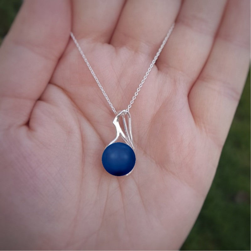 Hand holding a Lapis Crystal pearl luster necklace on a sterling silver chain from Ireland