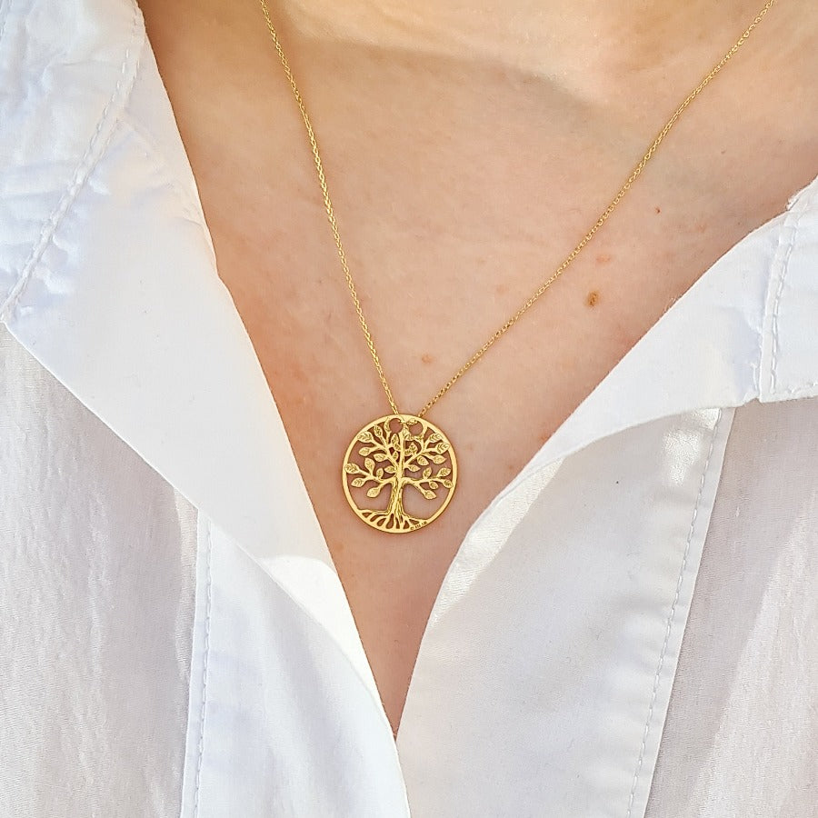Woman wearing a real solid gold tree of life necklace with fine chain, marked 585 14k gold, shop in Ireland