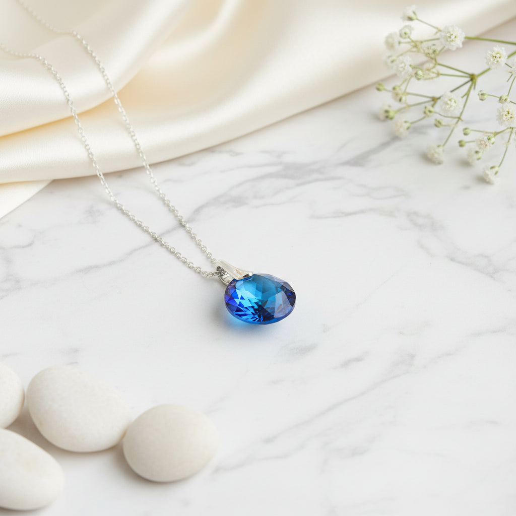 A stylish pendant necklace with sterling silver chain and a round pointy chaton crystal, Bermuda Blue, made by Magpie Gems in Ireland.