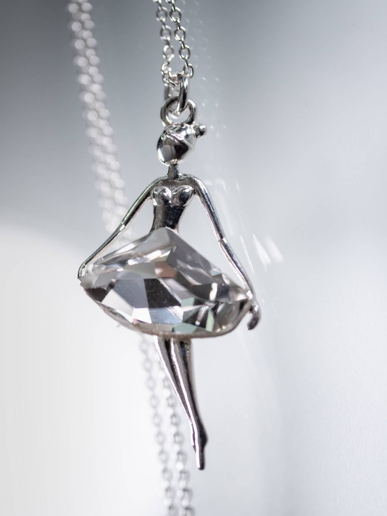Handcrafted in Ireland by Magpie Gems, this exquisite sterling silver pendant necklace glistens with a Crystal Clear dress-shaped crystal charm. Dangling from a delicate 925 silver chain, this piece is a testament to feminine grace, designed to celebrate and empower women and girls with its ethereal beauty.