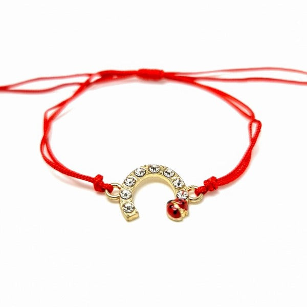 Gold plated horseshoe with crystals and a red ladybird charm, red macramé cord string bracelet shop in Ireland