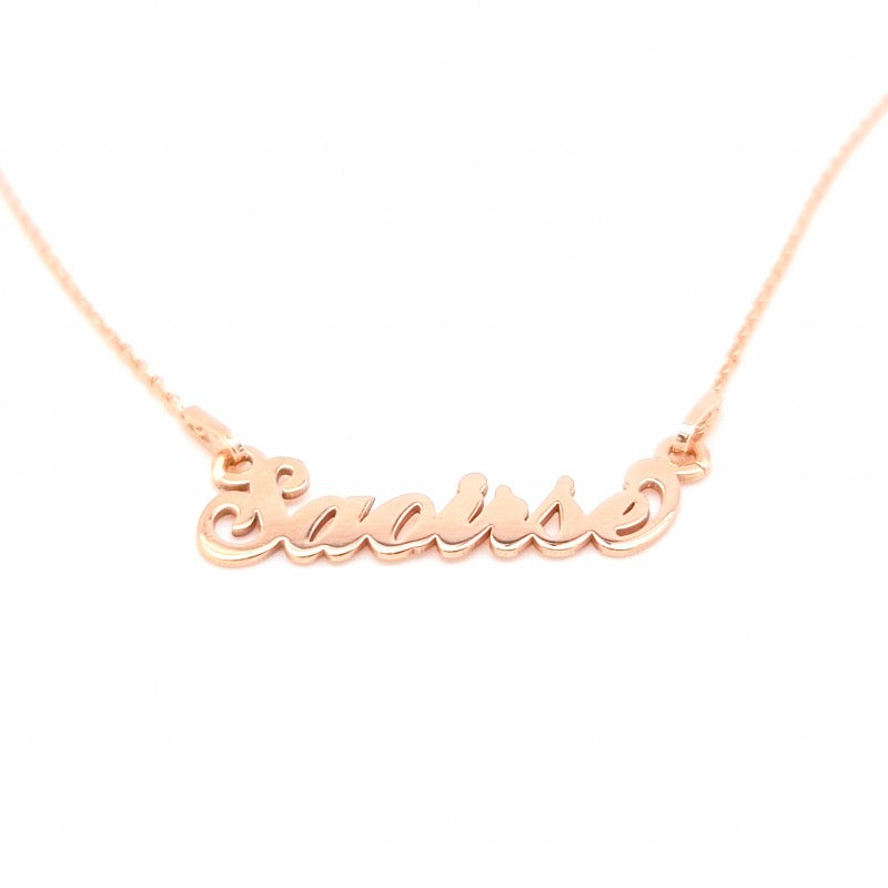 Close-up of a custom-made 'Saoirse' name necklace in rose gold, showcasing delicate cursive script on a plain white background.