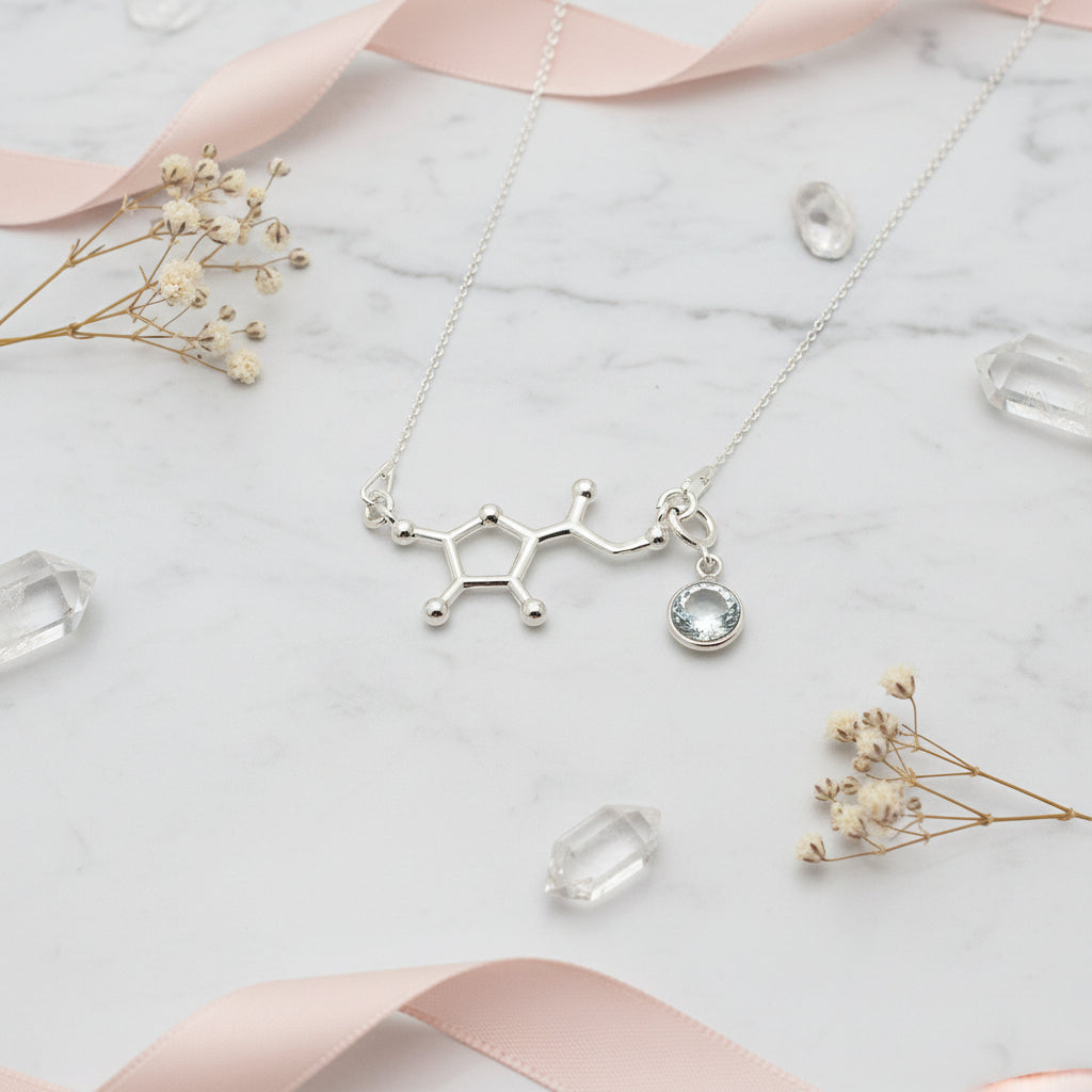 Sterling silver Vitamin C molecule necklace paired with a detachable clear April birthstone charm, crafted by Magpie Gems in Ireland.