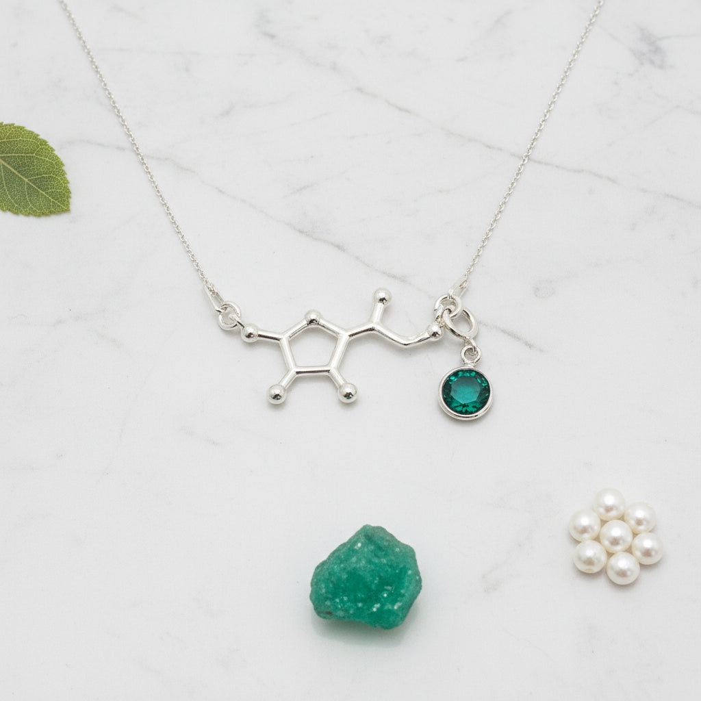 Silver Vitamin C molecule pendant with a detachable May Emerald birthstone charm, meaningful science jewellery by Magpie Gems.