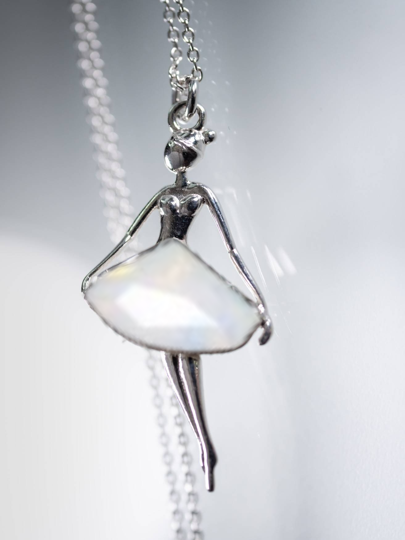 Charming sterling silver ballerina necklace featuring a radiant white opal crystal, presented by Magpie Gems in Ireland.